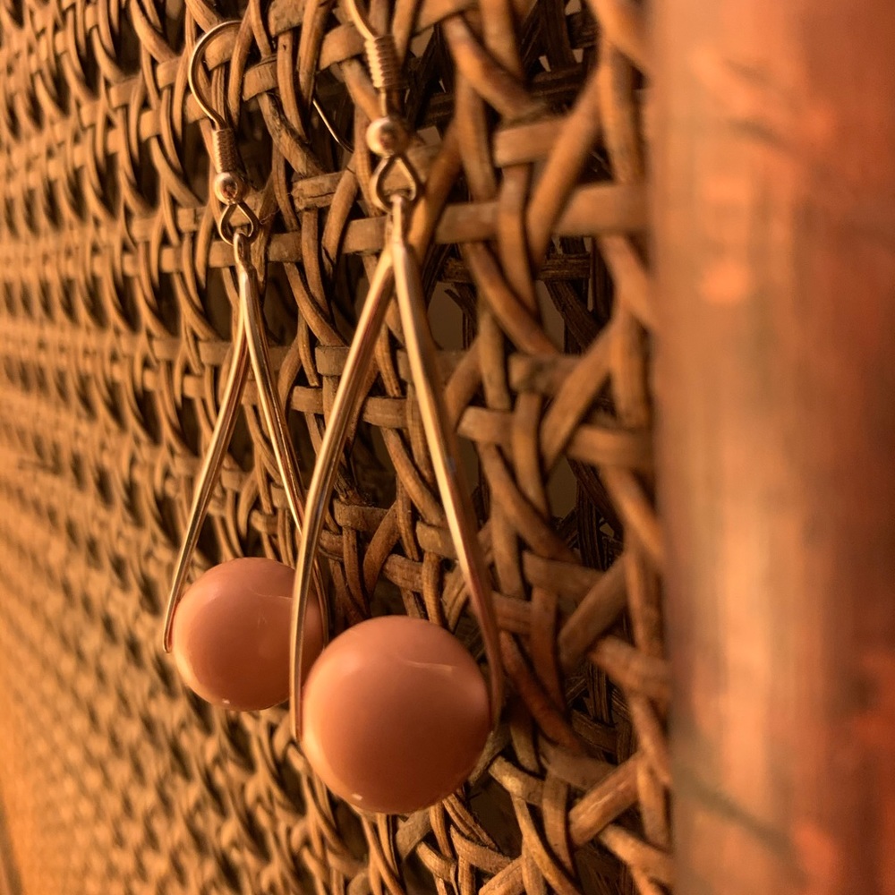 Silver earrings dangling with light pink balls